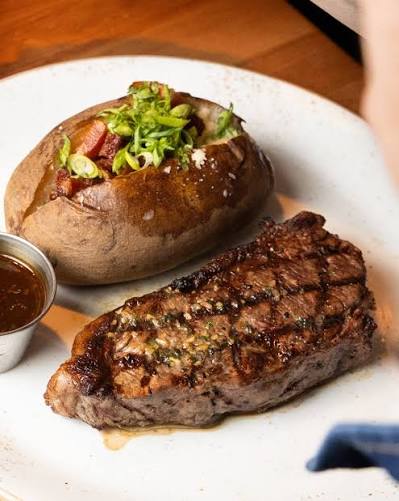 A grilled steak and loaded baked potato at JaK's Grill