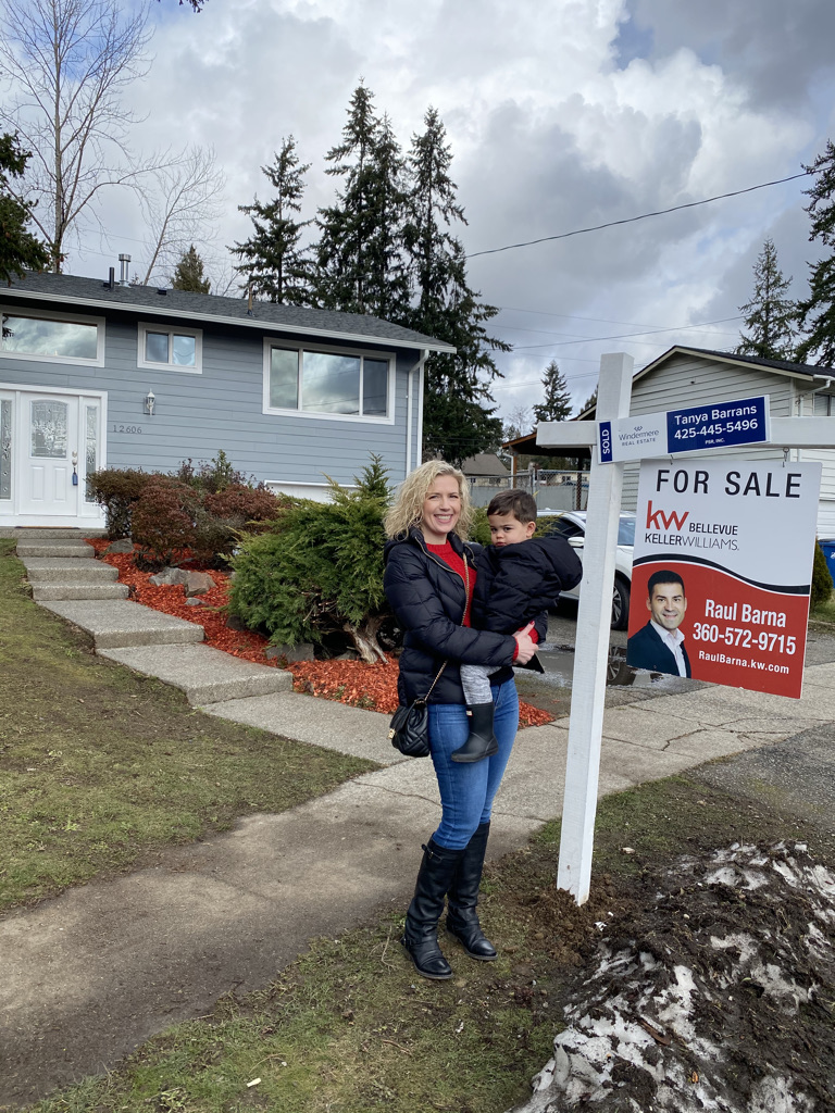 Tanya holding Asher in front of the home she bought in Renton